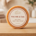 Pink Milk & Oats natural goat milk soap on a wooden surface with a blurred background